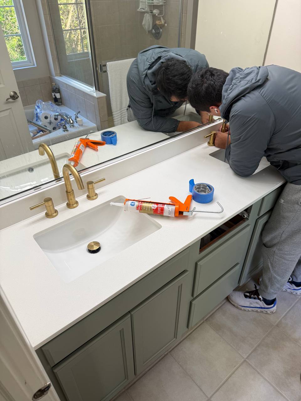 Bathroom vanity with brushed gold faucet and marble-look countertop