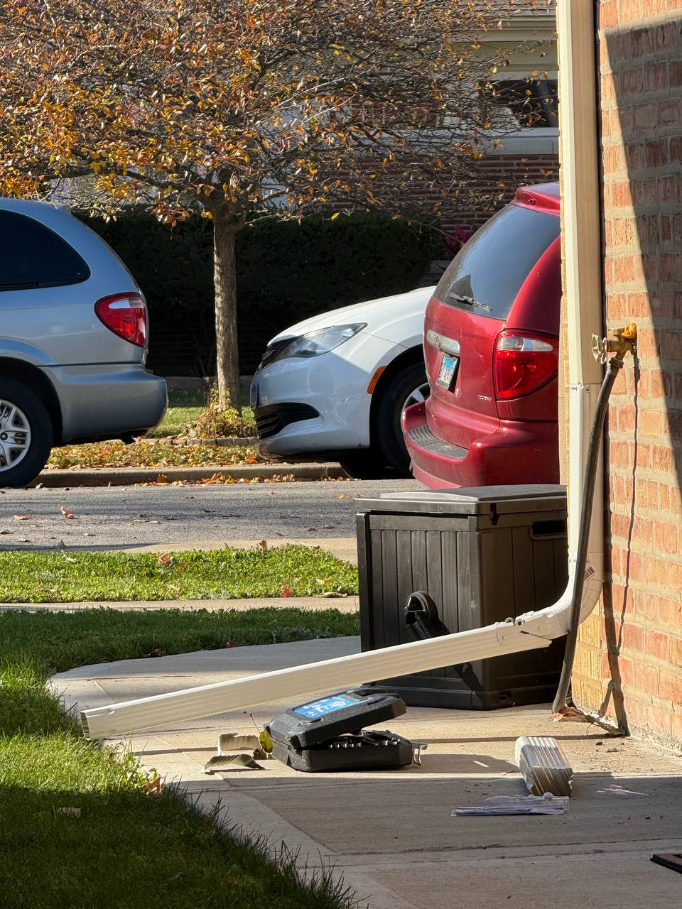 Gutter downspout repair and reattachment on residential exterior