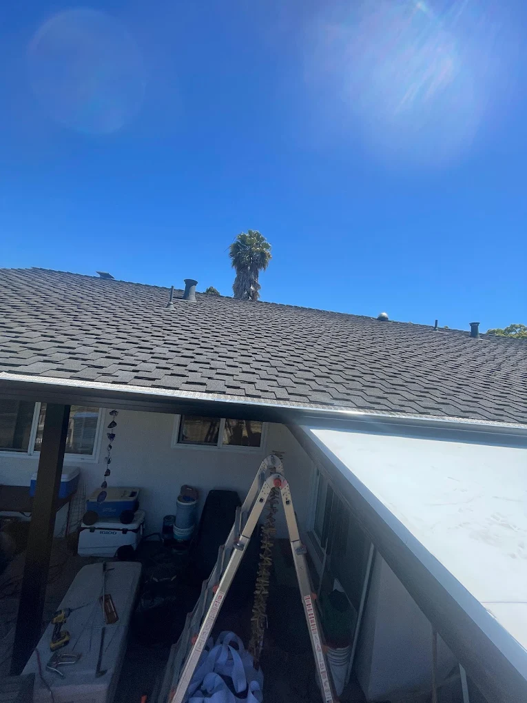 Seamless aluminum gutter installation along roofline with proper slope