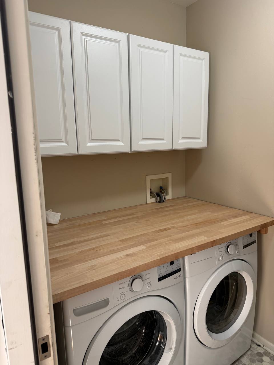 Laundry room cabinets with butcher block countertop and built-in sorting bins